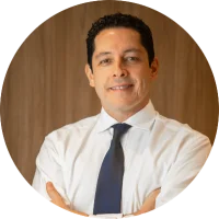 Retrato de Dr. Felipe Fagundes Bassols, médico ginecologista e ultrassonografista, homem de jaleco branco, semblante sério e acolhedor, fundo neutro, iluminação suave de estúdio, fotografia profissional realista