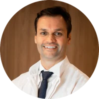 Retrato de Dr. Enio Ziemiecki Junior, médico radiologista intervencionista, homem de jaleco branco, expressão confiante, fundo neutro, iluminação suave de estúdio, fotografia profissional realista